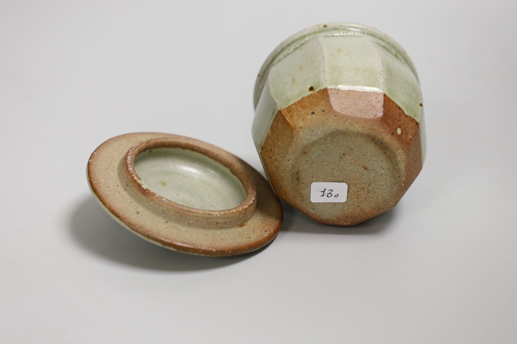 Richard Batterham (1936 – 2021), a cut sided stoneware jar and pointed cover with sage coloured glaze. 10.5cm high